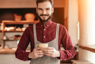 Bir fincan sıcak içecekle dost canlısı bir barista.