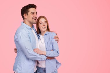 İyimser çift sarılıyor ve başka tarafa bakıyor.