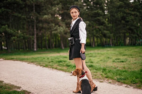 Mujer con estilo con perro paseando por el callejón del parque —  Fotos de Stock