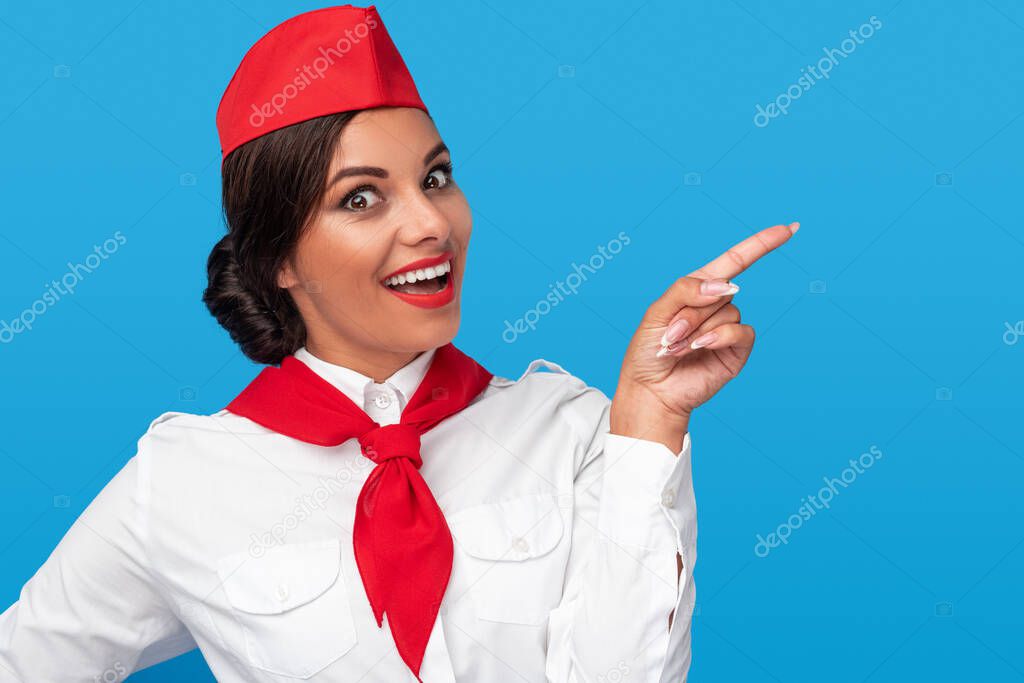 Excited stewardess pointing aside and smiling