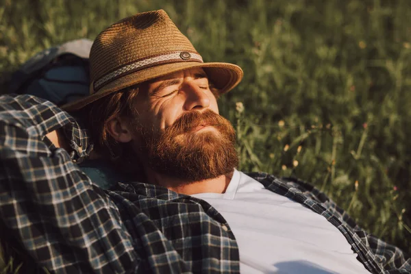 Carefree adult man lying on grassy field — Stock Photo, Image