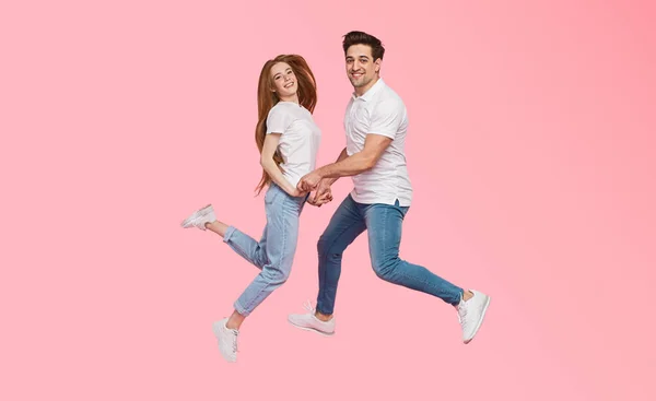 Jovem casal alegre pulando e dançando — Fotografia de Stock