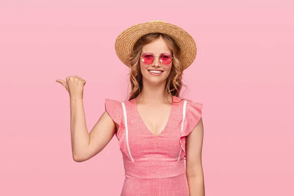 Cheerful young woman in summer outfit pointing aside — Stock Photo, Image