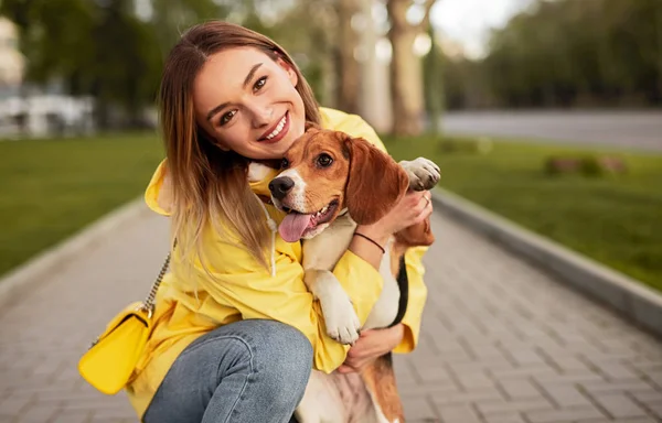 Happy woman hugging dog in park — Stock Photo, Image