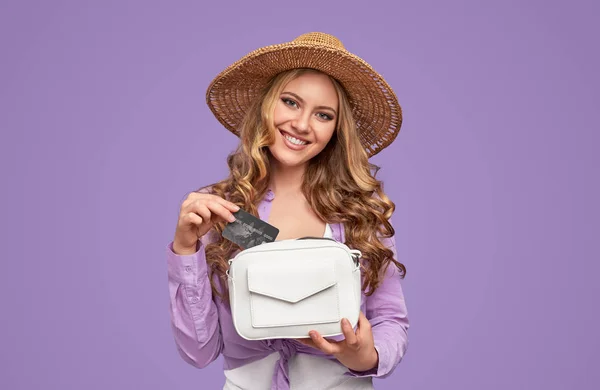 Щаслива модна жінка з кредитною карткою і маленькою сумкою дивиться на камеру — стокове фото