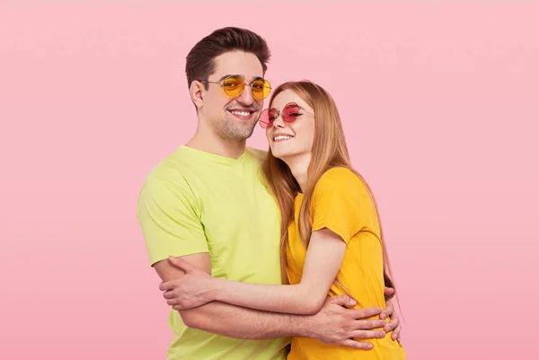 Glücklich umarmendes Paar auf rosa Hintergrund — Stockfoto