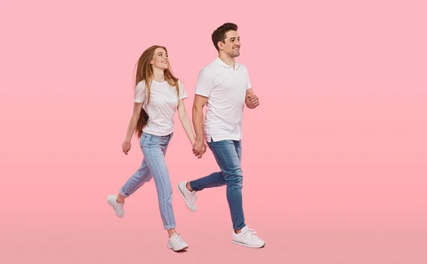 Pareja feliz caminando juntos sobre fondo rosa — Foto de Stock