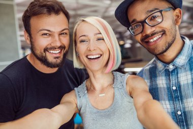 Neşeli çok ırklı meslektaşlar işten sonra selfie çekiyorlar.