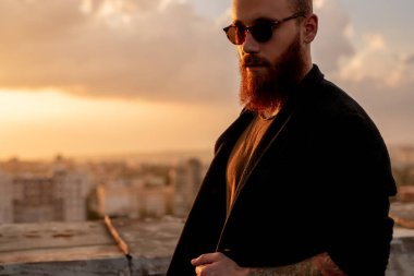 Günbatımında çatıda şık bir adam