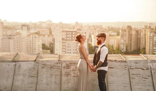 Stylish couple holding hands on roof — 스톡 사진