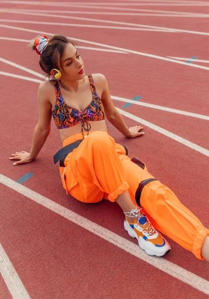 Jovem desportista ouvindo música na pista de corrida — Fotografia de Stock