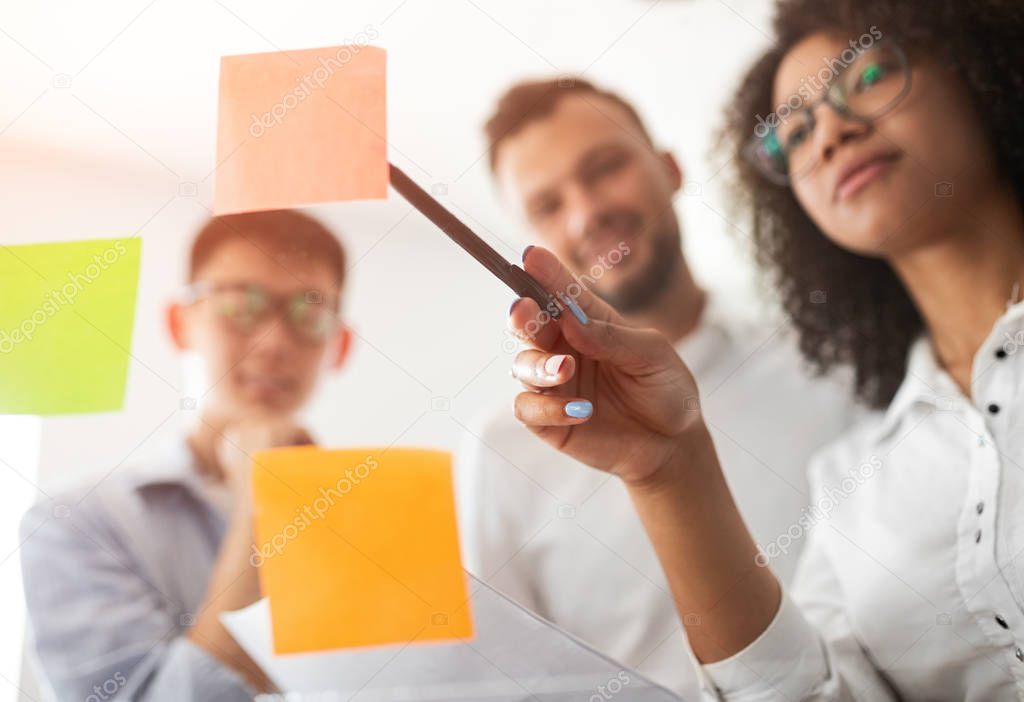 Diverse office workers discussing sticky notes