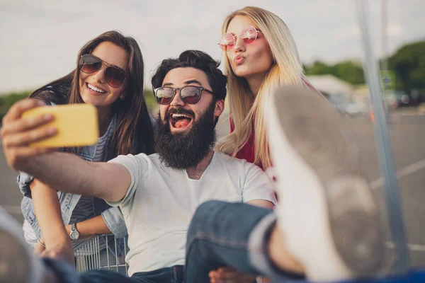 Homem barbudo tomando selfie com mulheres durante as compras — Fotografia de Stock