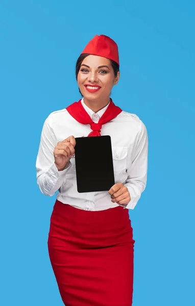 Vrolijke stewardess reclame luchtvaartmaatschappij app op tablet — Stockfoto