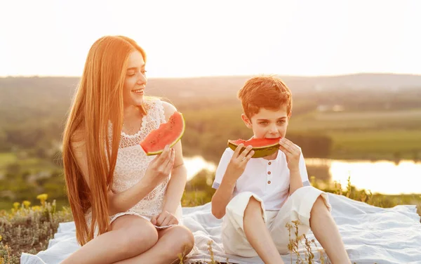 Crianças ativas felizes comendo melancia no prado — Fotografia de Stock