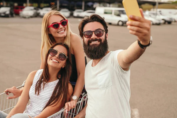 Delighted modern friends taking selfie during shopping — 图库照片