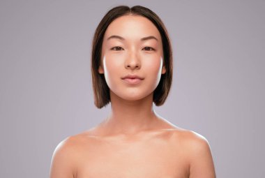 Chinese lady with clean skin looking at camera