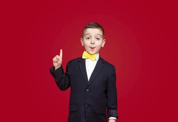 Cute boy in suit pointing up — 图库照片