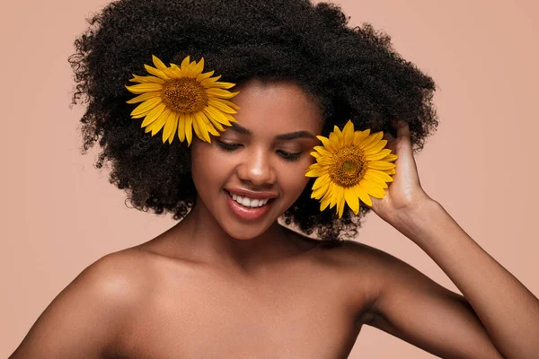 Happy kale schouders vrouw met zonnebloemen op roze achtergrond — Stockfoto