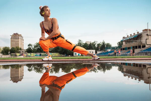 Trendy vrouwelijke training in de buurt van plas op het stadion — Stockfoto