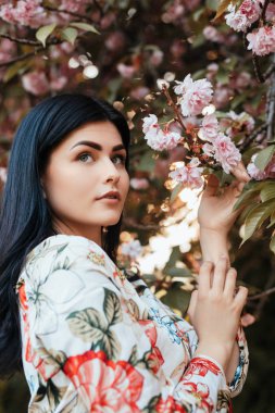 Elegant woman near blooming tree