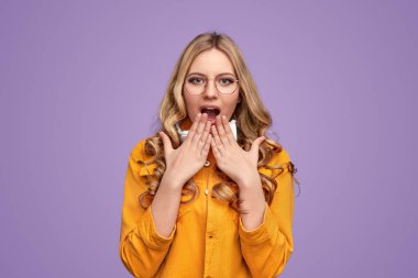 Shocked stylish blonde female looking at camera