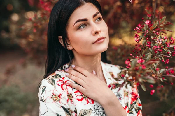 Dreamy woman near blooming tree — Stockfoto