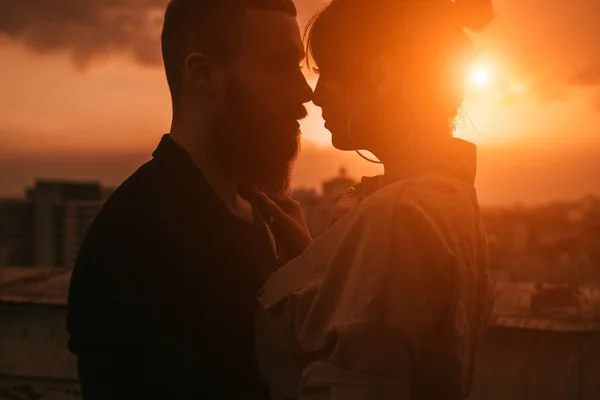 Sensual casal romântico beijando no telhado ao pôr do sol — Fotografia de Stock