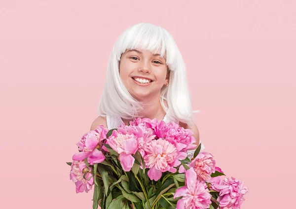 Adolescente feliz em peruca carregando flores — Fotografia de Stock