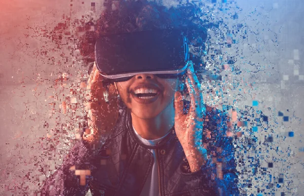 Cheerful black woman disintegrating during virtual reality exploration — Stock fotografie