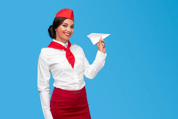 Cheerful Hispanic air hostess with paper plane — Stockfoto