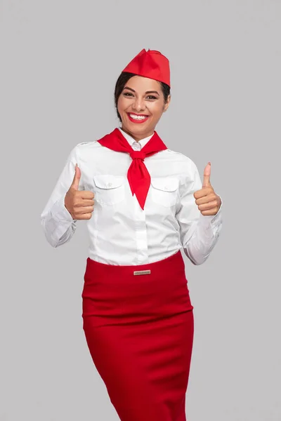 Happy adult air hostess showing thumb signal — Stok fotoğraf