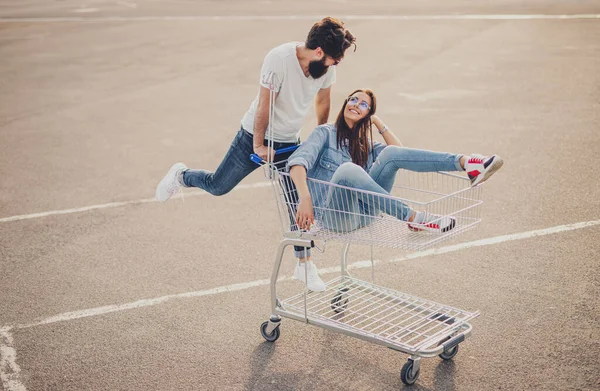 Happy couple riding shopping trolley — 图库照片