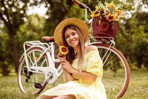 Happy female with flower resting near bike