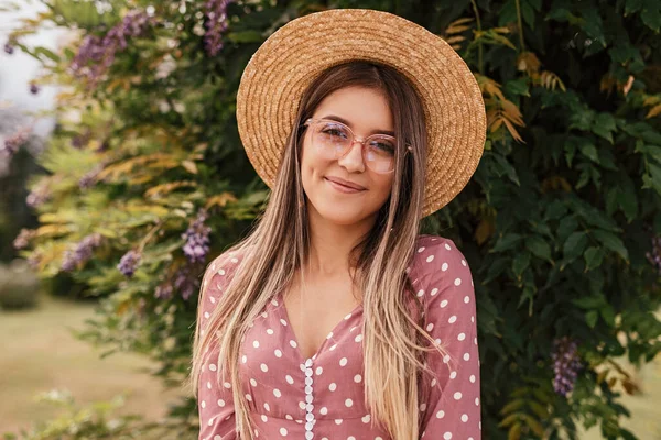 Jovem mulher alegre em chapéu e óculos descansando no jardim de verão — Fotografia de Stock