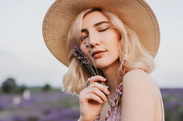 Спокійна жінка насолоджується квітами лаванди — стокове фото