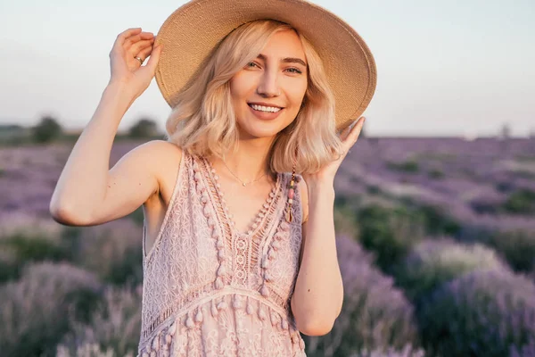 Smiling woman in straw hat in field — Stockfoto