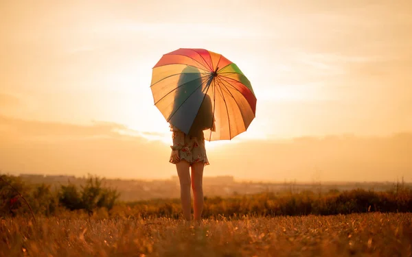 Mujer anónima con paraguas soñando al atardecer — Foto de Stock