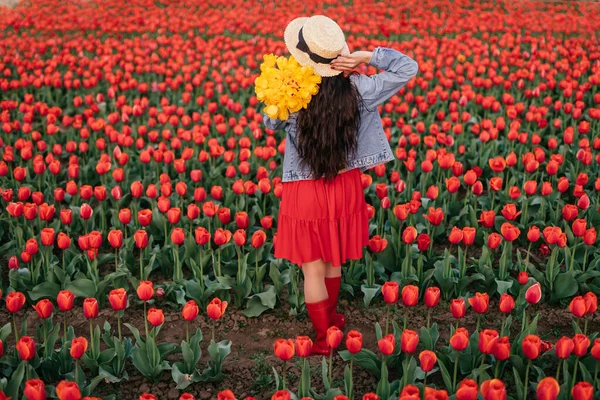 Anonyme Frau mit Blumenstrauß im blühenden Feld — Stockfoto