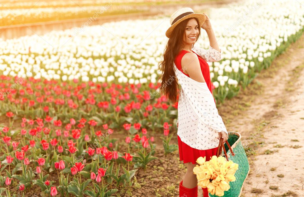 Cheerful woman standing near tulip field