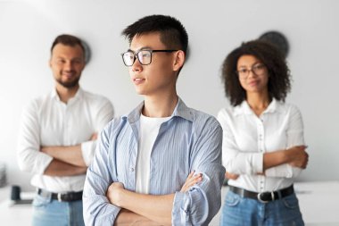 Successful multiracial colleagues standing in light office