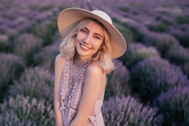 Charming young woman standing on lavender field