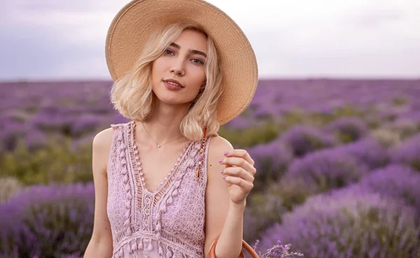Розслаблена стильна молода жінка, що стоїть на квітковому лавандовому полі — стокове фото