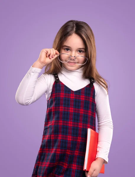 Imádnivaló iskolás lány tankönyv beállítása szemüveg — Stock Fotó