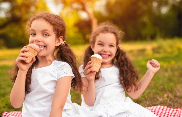 Glückliche Schwestern essen Eis im Park — Stockfoto