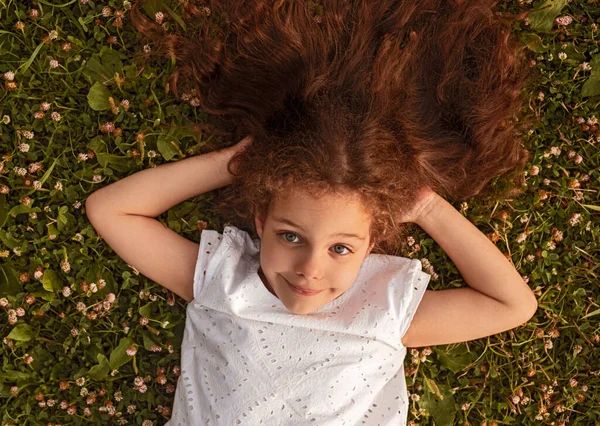 Маленька дівчинка лежить на траві — стокове фото