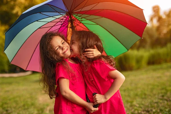 Menina Alegre Vestido Vermelho Beijando Irmã Gêmea Sob Guarda Chuva — Fotografia de Stock