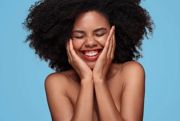 Gelukkig Afro-Amerikaanse vrouw met perfecte huid op blauwe achtergrond — Stockfoto