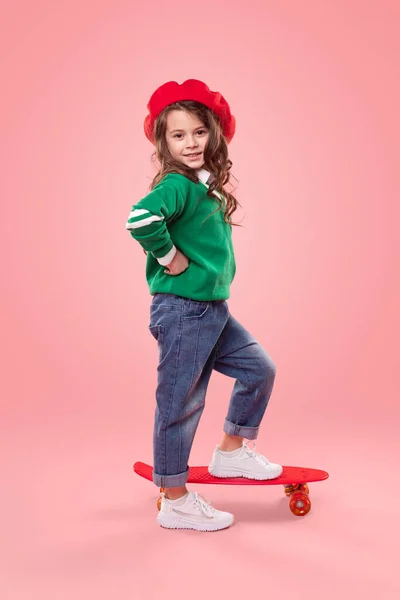 Menina na moda com skate sorrindo para a câmera — Fotografia de Stock