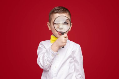 Büyüteçli meraklı çocuk.